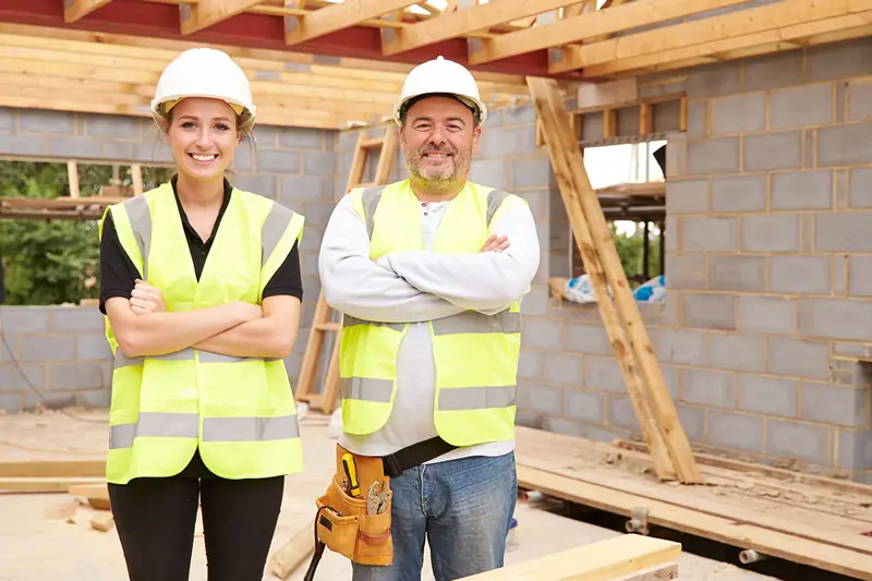 Two builders in hard hats and high-visibility vests on their site.